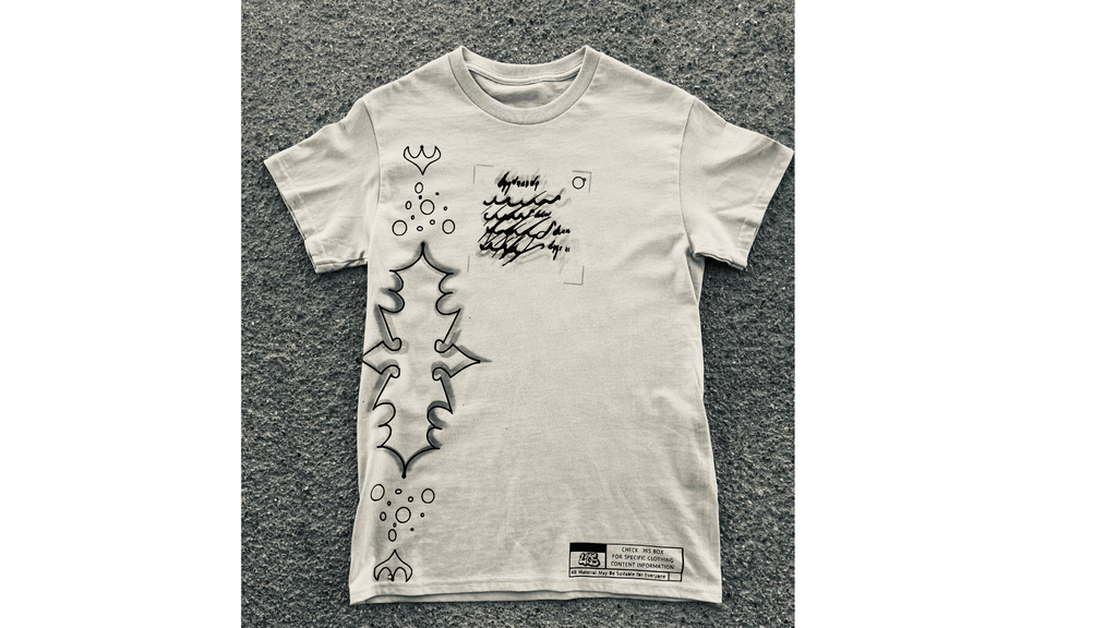 White t-shirt with black graphic design on a textured gray surface
